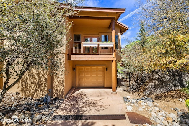 4710 Echo Canyon Pl, Prescott, AZ 86301 - view of front facade with stucco siding, fence, driveway, a balcony, and an attached garage