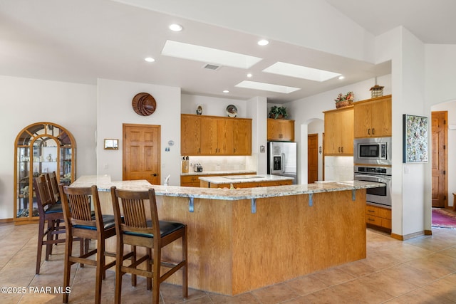 4710 Echo Canyon Pl, Prescott, AZ 86301 - kitchen featuring appliances with stainless steel finishes, visible vents, brown cabinets, and backsplash