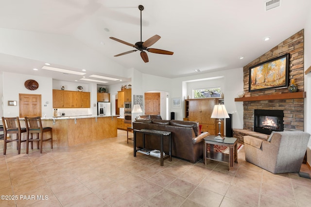4710 Echo Canyon Pl, Prescott, AZ 86301 - living area featuring light tile patterned floors, vaulted ceiling, a fireplace, visible vents, and a ceiling fan
