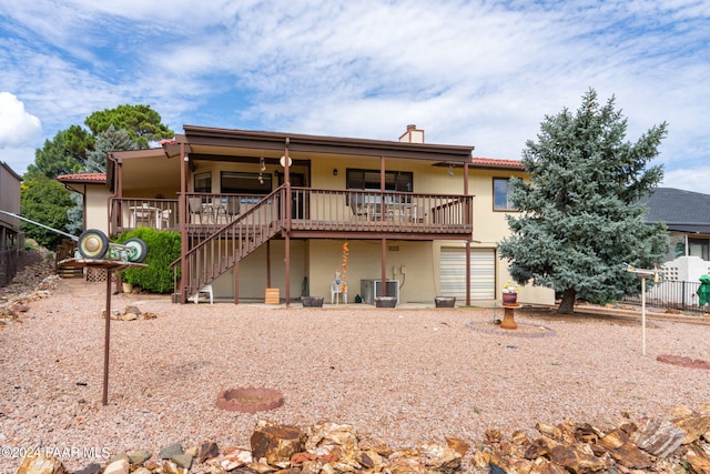 rear view of house featuring central AC unit and a wooden deck