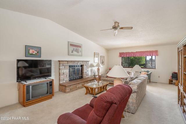 living room with ceiling fan, a stone fireplace, a textured ceiling, vaulted ceiling, and light carpet