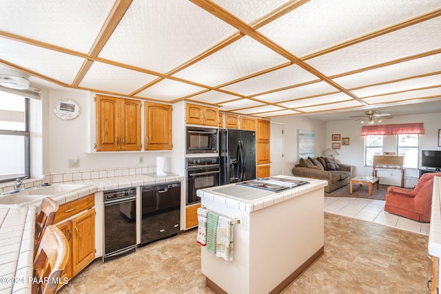 kitchen with ceiling fan, a textured ceiling, tile counters, and black appliances