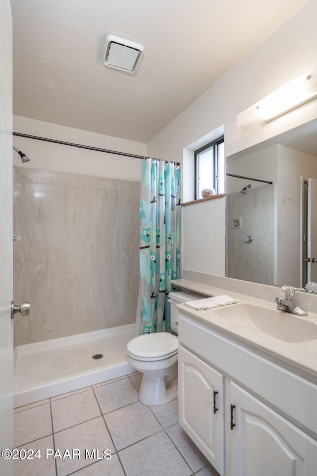 bathroom with tile patterned floors, vanity, curtained shower, and toilet