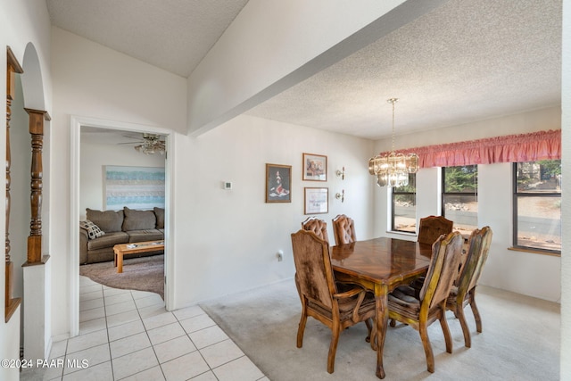 tiled dining space featuring a textured ceiling and ceiling fan with notable chandelier