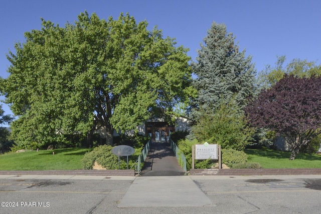 view of property hidden behind natural elements with a front lawn