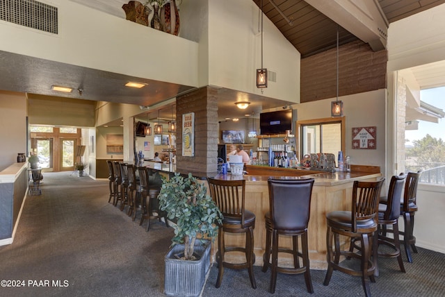 bar featuring beam ceiling, french doors, high vaulted ceiling, decorative light fixtures, and carpet