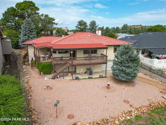 back of house featuring a patio, a wooden deck, and central air condition unit