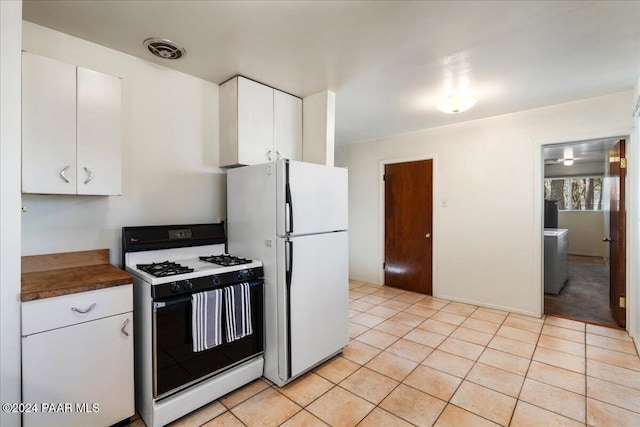 kitchen with white cabinets, white appliances, and light tile patterned flooring