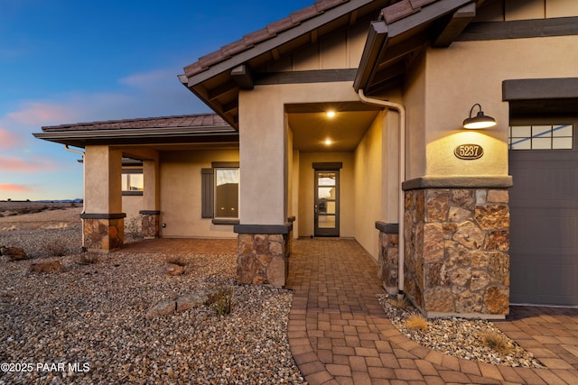 exterior entry at dusk with a garage