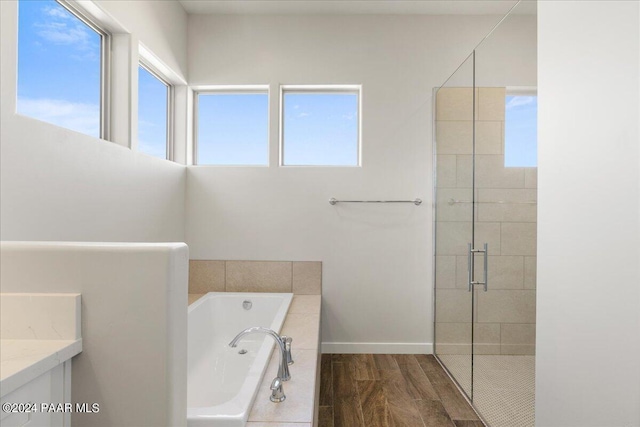 bathroom featuring vanity, hardwood / wood-style floors, a wealth of natural light, and shower with separate bathtub