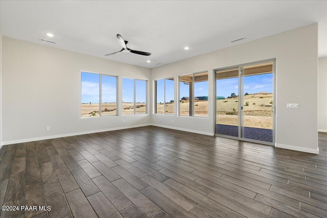 empty room with ceiling fan and dark hardwood / wood-style flooring