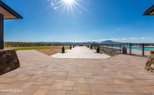 view of patio with a fenced in pool and a mountain view