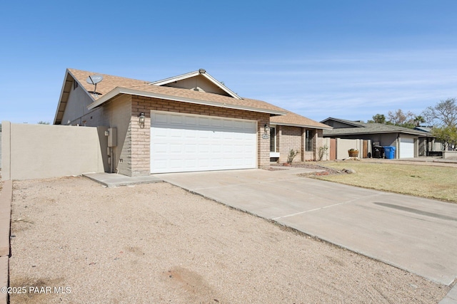 ranch-style house featuring fence, concrete driveway, a shingled roof, a garage, and brick siding