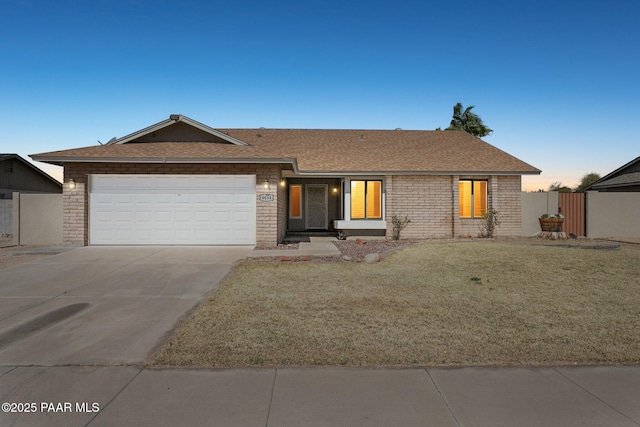 single story home featuring a front yard, fence, a shingled roof, concrete driveway, and a garage