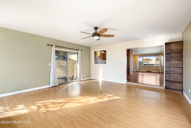 unfurnished living room featuring ceiling fan, light hardwood / wood-style floors, and a wealth of natural light