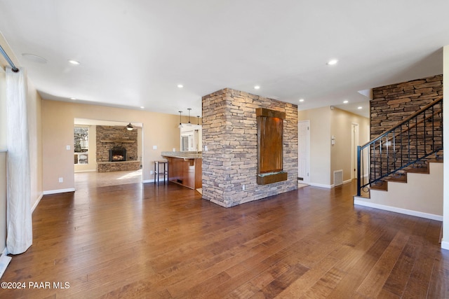 unfurnished living room with a fireplace and dark wood-type flooring