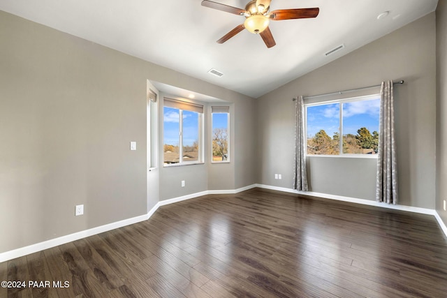 spare room featuring dark hardwood / wood-style floors, a healthy amount of sunlight, ceiling fan, and vaulted ceiling