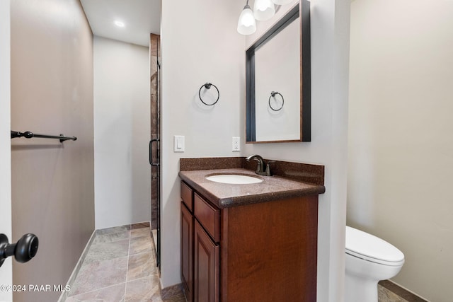 bathroom with vanity, toilet, and a shower with shower door