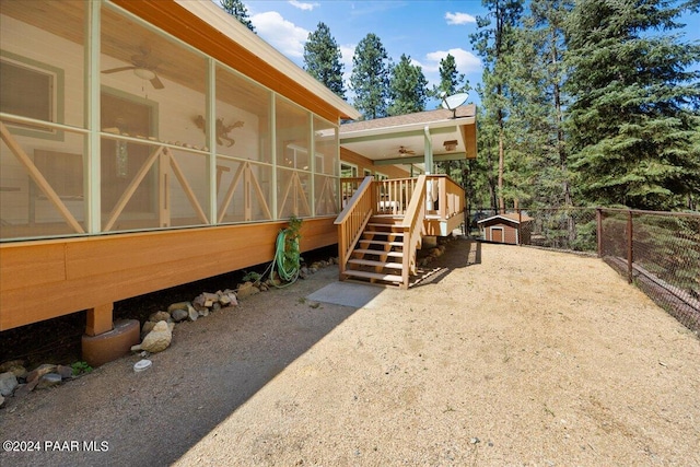 exterior space with stairs, fence, an outdoor structure, and a sunroom