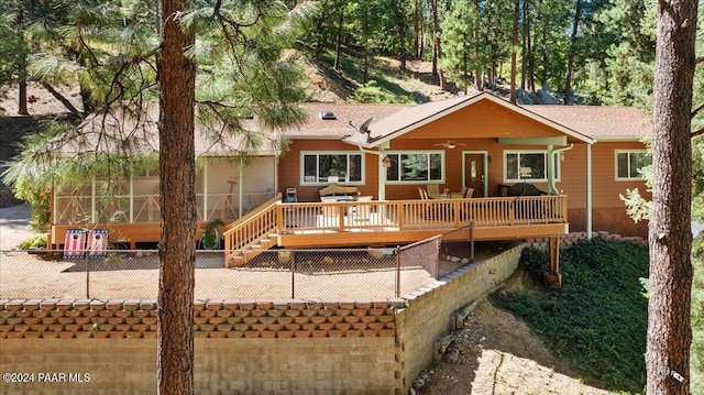 back of house with stairway, a wooden deck, ceiling fan, and fence