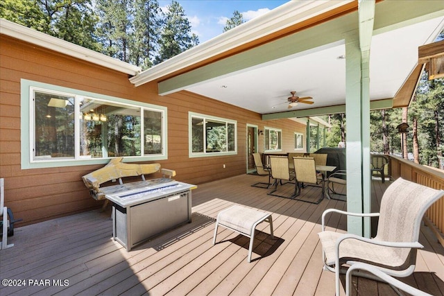 deck with outdoor dining area, grilling area, and a ceiling fan