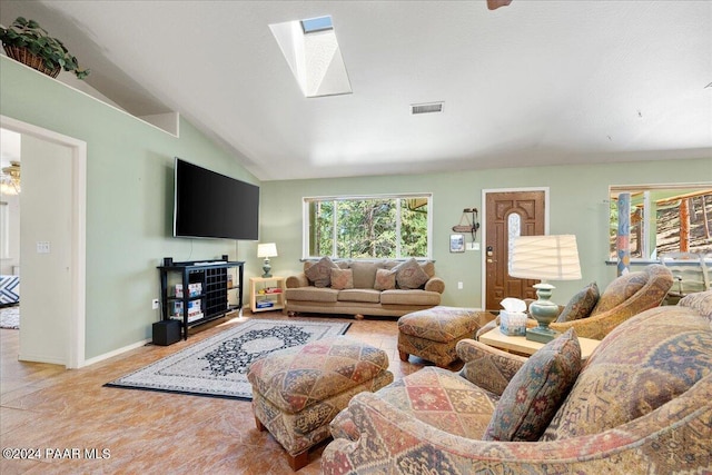 living room featuring visible vents, vaulted ceiling with skylight, and baseboards