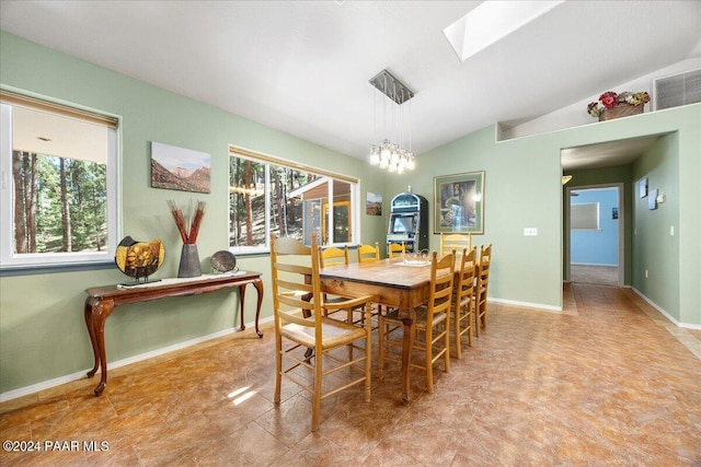 dining room with visible vents, vaulted ceiling with skylight, and baseboards