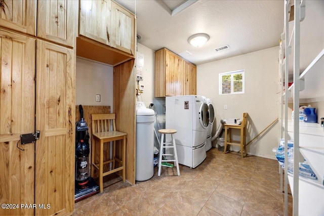 washroom featuring visible vents, cabinet space, and separate washer and dryer