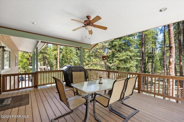 wooden terrace featuring outdoor dining area and a ceiling fan