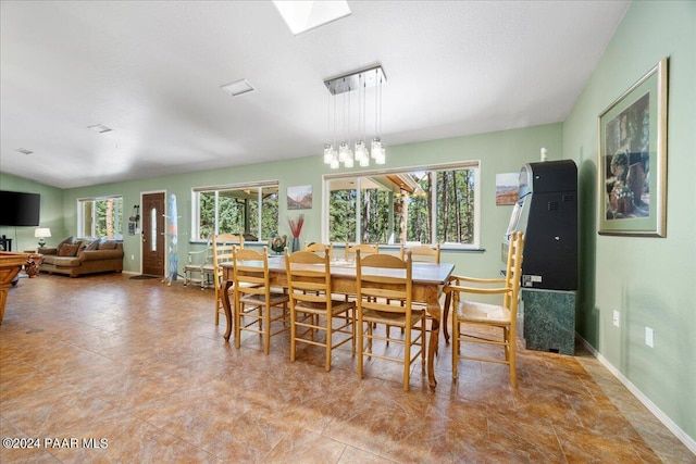 dining area with baseboards, a healthy amount of sunlight, and a skylight