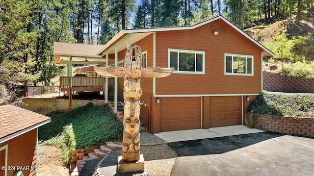 view of home's exterior featuring stairs, an attached garage, and driveway