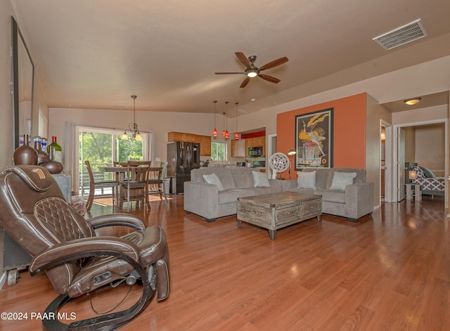 living room with ceiling fan, lofted ceiling, and light wood-type flooring