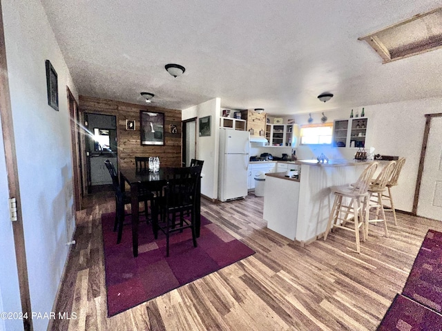 dining space featuring a textured ceiling and light wood-type flooring