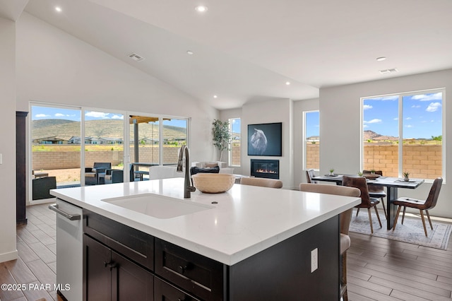 5711 E Hahn St, Prescott Valley, AZ 86314 - kitchen with open floor plan, recessed lighting, a kitchen island with sink, light wood finished floors, and a glass covered fireplace