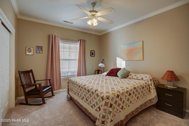 carpeted bedroom featuring ceiling fan, a closet, and crown molding