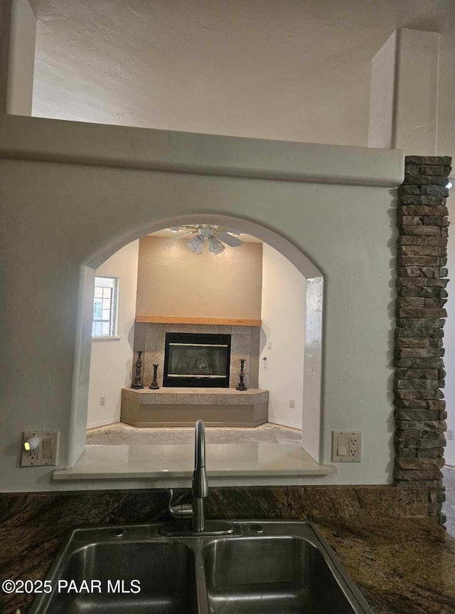 kitchen featuring a tiled fireplace and sink