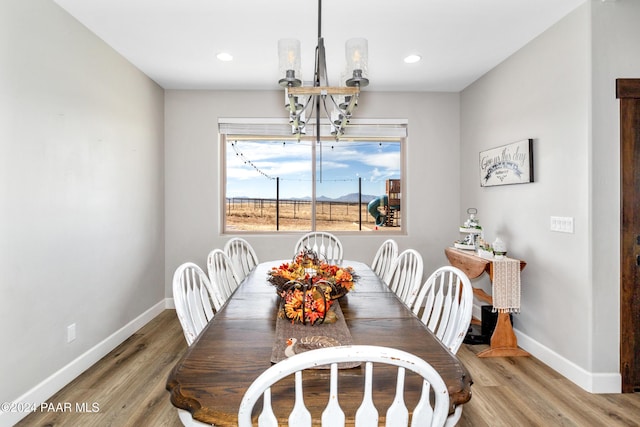 dining space featuring recessed lighting, baseboards, an inviting chandelier, and wood finished floors