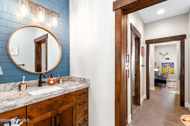 ensuite bathroom with tile patterned floors, baseboards, connected bathroom, and vanity