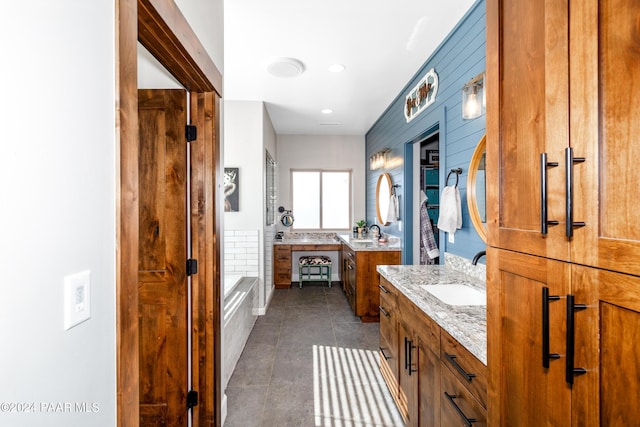 bathroom with a tub, tile patterned flooring, two vanities, and a sink