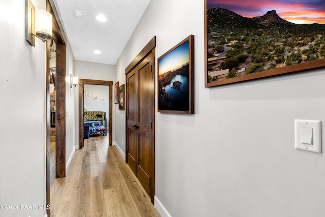 hall featuring recessed lighting, light wood-type flooring, and baseboards