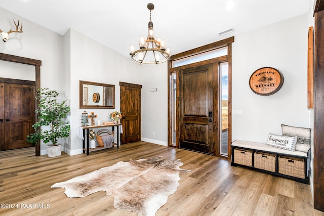 entrance foyer featuring baseboards, a chandelier, visible vents, and light wood-style floors