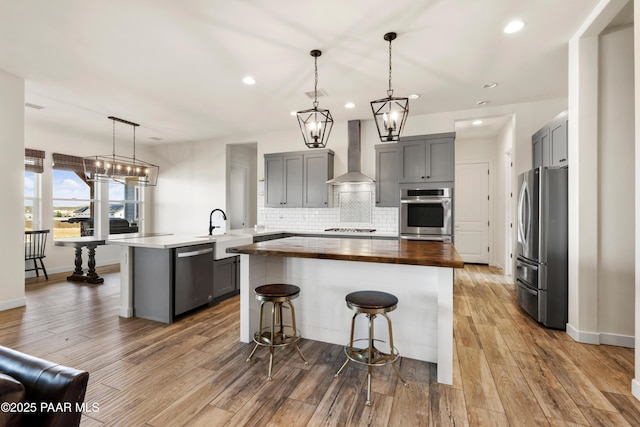 9550 N Manger Rd, Prescott Valley, AZ 86314 - kitchen featuring wall chimney exhaust hood, stainless steel appliances, butcher block counters, gray cabinetry, and recessed lighting
