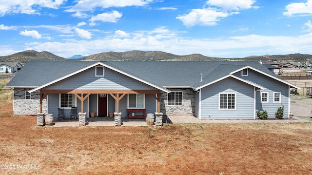 9550 N Manger Rd, Prescott Valley, AZ 86314 - back of property with a mountain view, stone siding, a shingled roof, and covered porch