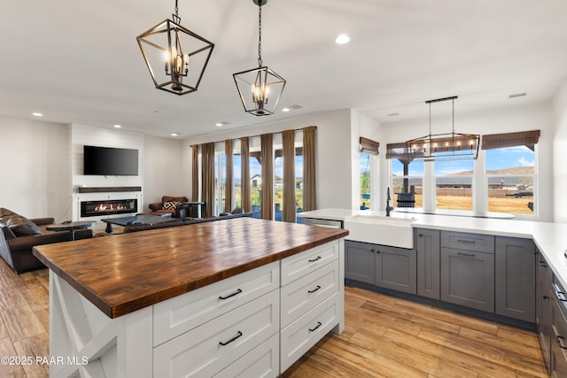 9550 N Manger Rd, Prescott Valley, AZ 86314 - kitchen with wooden counters, open floor plan, a fireplace, light wood-type flooring, and recessed lighting