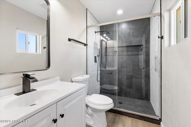 bathroom with hardwood / wood-style floors, vanity, toilet, and an enclosed shower