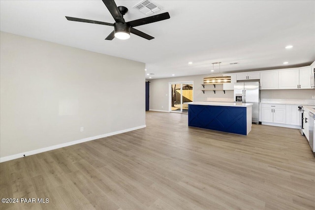 kitchen featuring pendant lighting, white cabinets, stainless steel fridge, light hardwood / wood-style floors, and a kitchen island