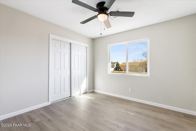 unfurnished bedroom with a closet, light hardwood / wood-style floors, and ceiling fan