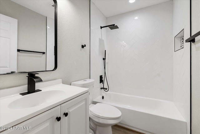 full bathroom with hardwood / wood-style floors, vanity, toilet, and tiled shower / bath