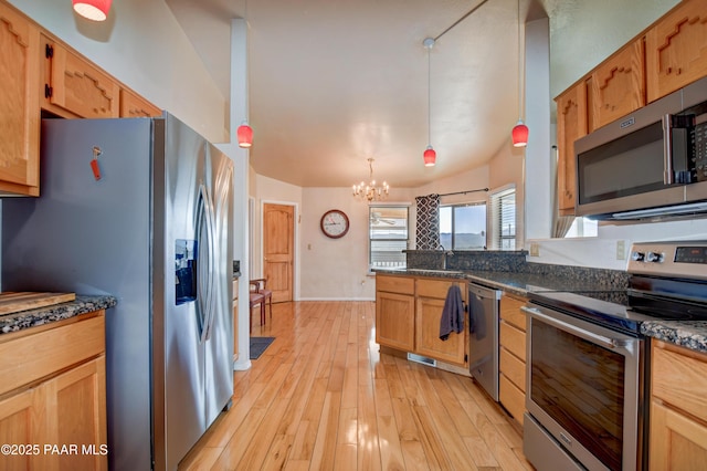 kitchen featuring a chandelier, light hardwood / wood-style flooring, appliances with stainless steel finishes, pendant lighting, and dark stone counters