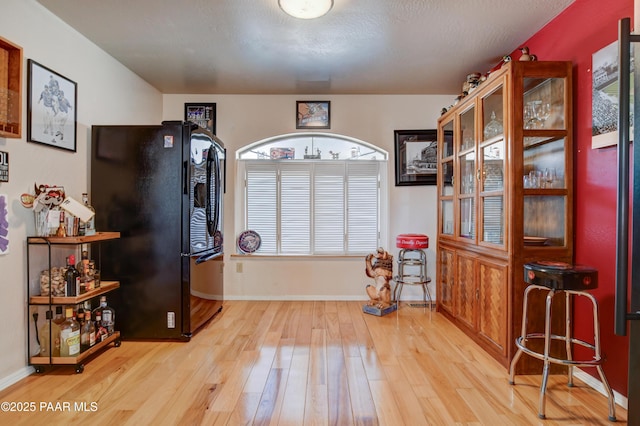 misc room with light hardwood / wood-style floors and a textured ceiling